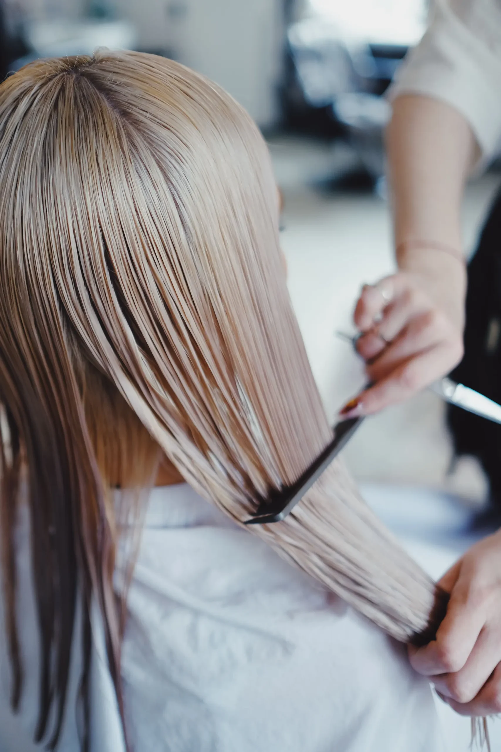 Smooth blonde hair being styled at a hair salon